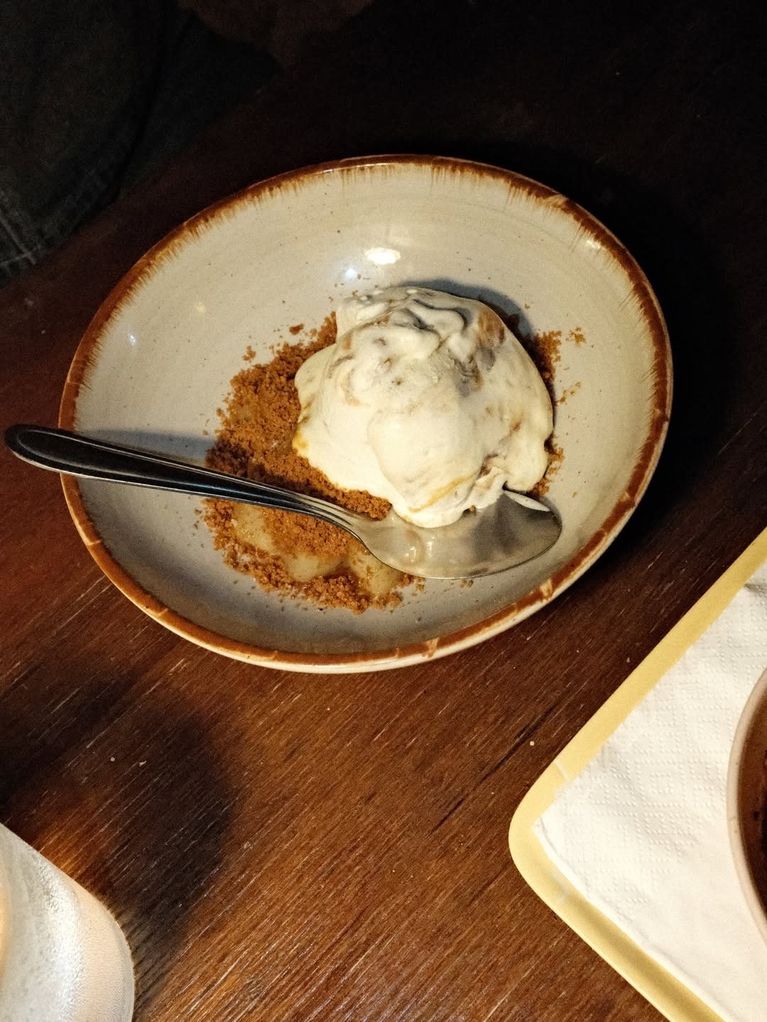 Taça com crumble e uma bola de gelado, com uma colher