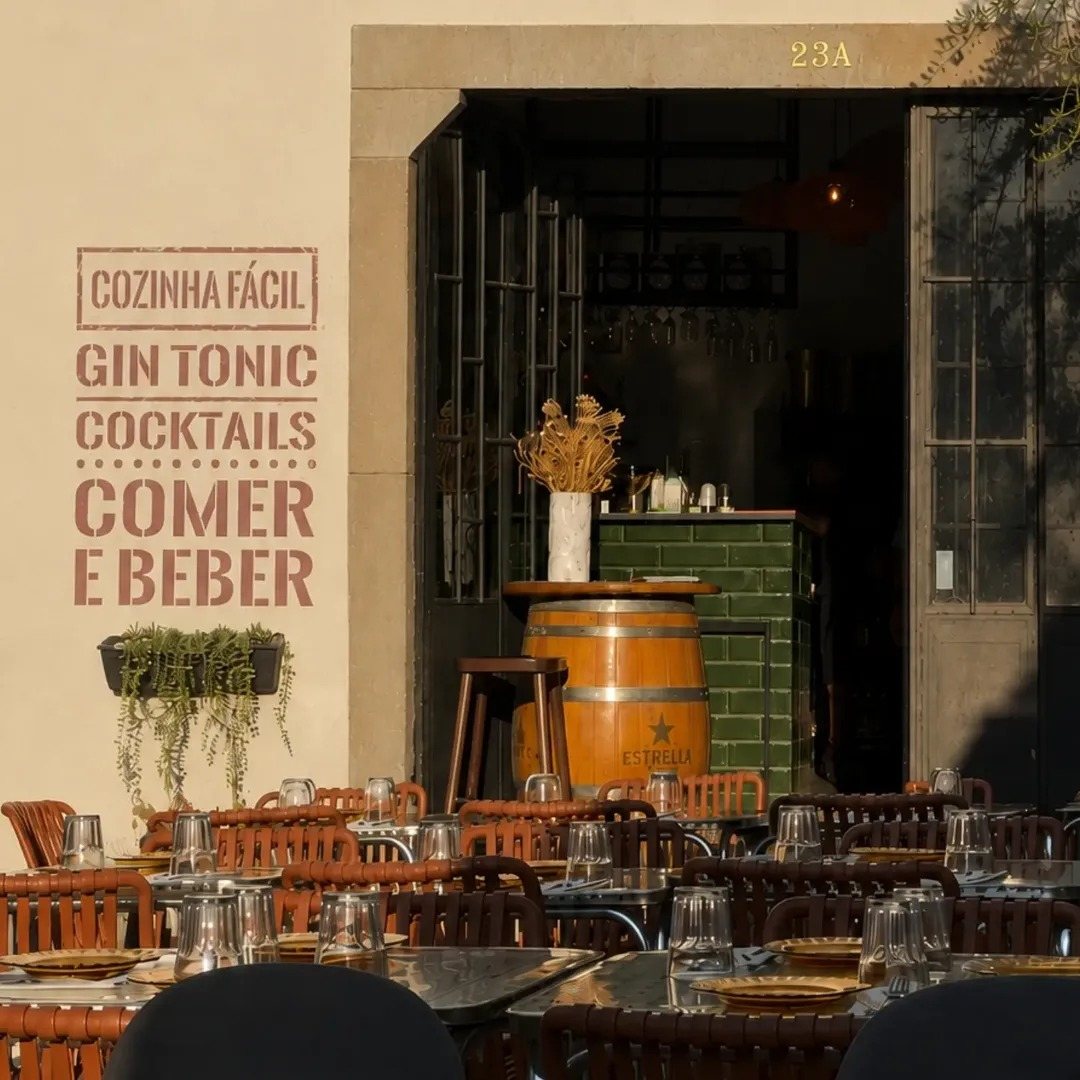 Entrada do Canalha com mesas cá fora, um barril à porta e as palavras Cozinha Fácil, Gin Tonic, Cocktails, Comer e Beber pintadas na parede